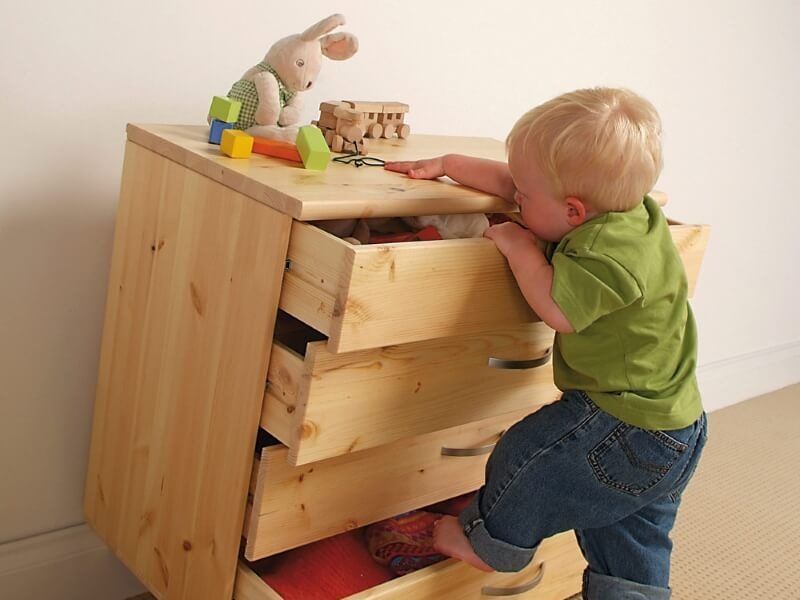 Child attempting to climb a set of drawers