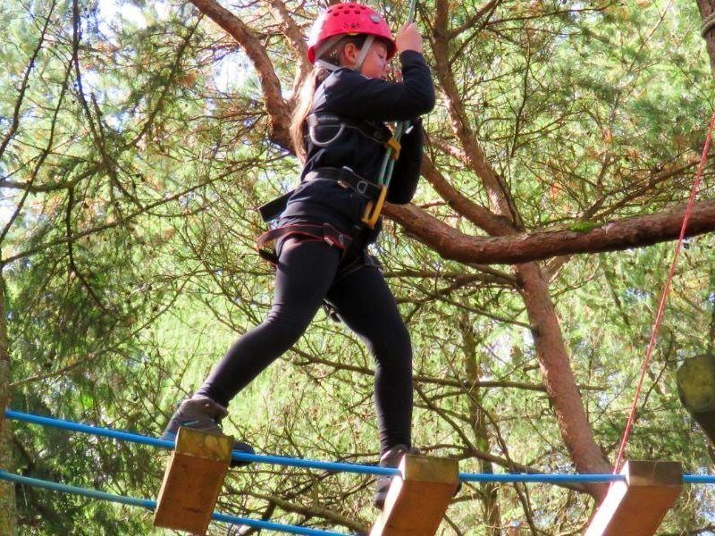 Child walking across a rope bridge