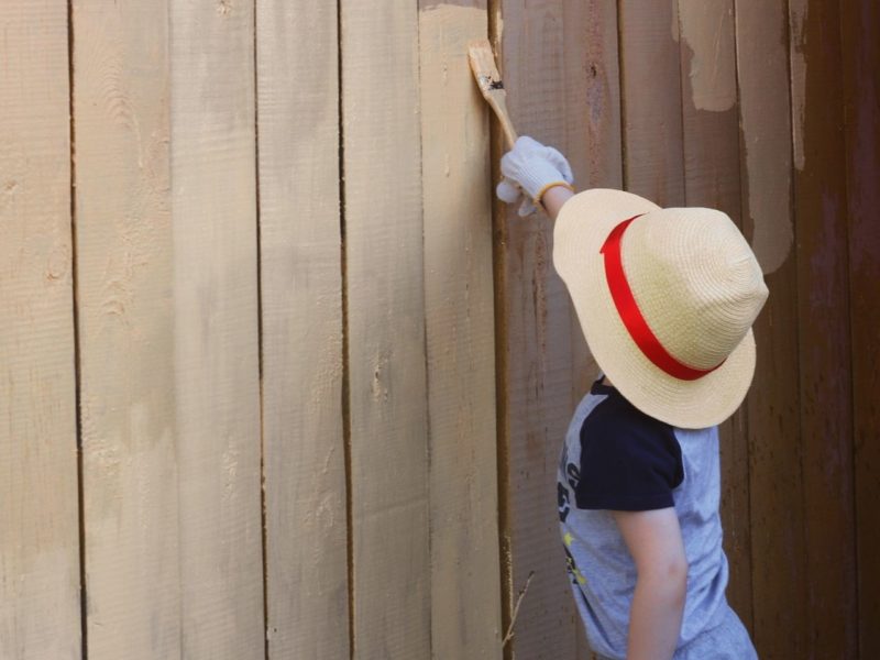 Child painting a fence