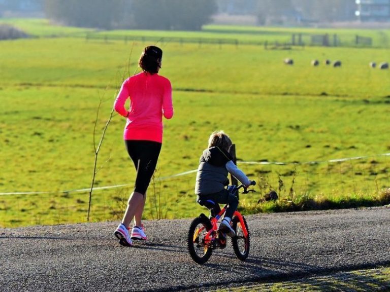 Mum jogging with child riding bike