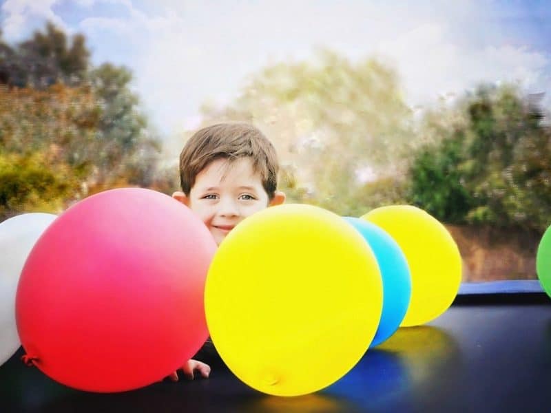 Boy with brightly coloured balloons