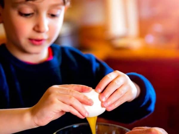 Boy breaking an egg