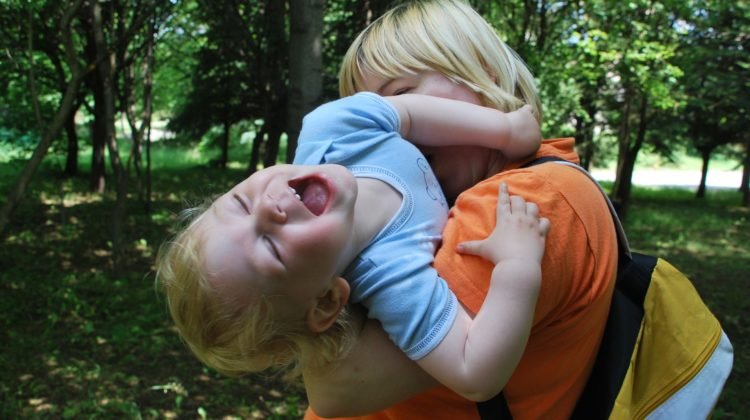 Mum cuddling her playful son