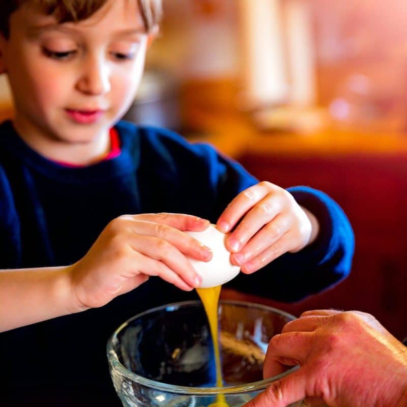 Child cooking with an egg