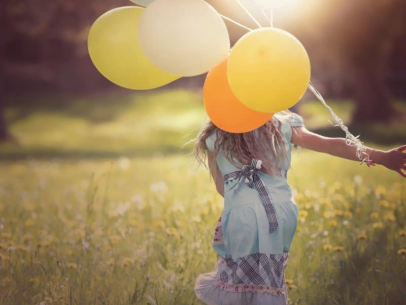 Girl running with balloons