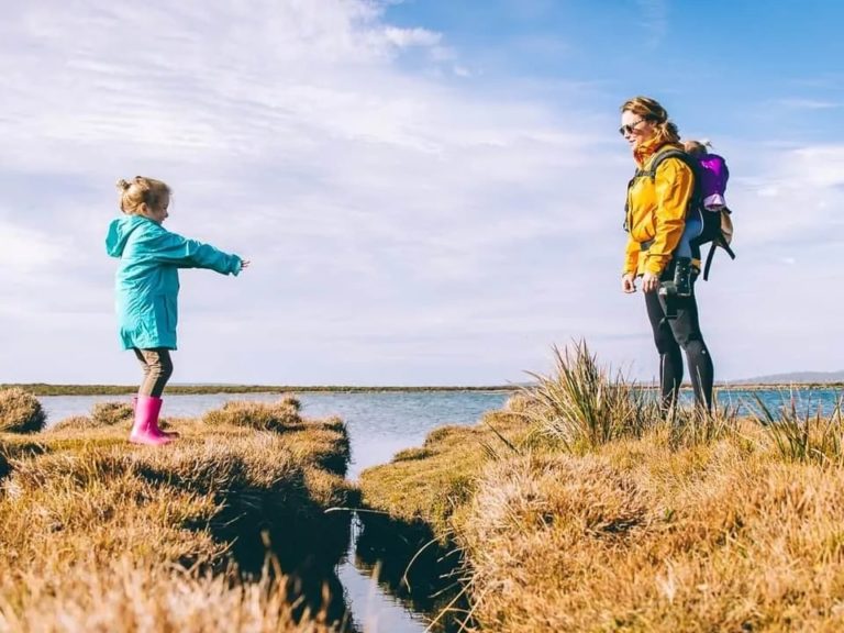 Mum and duaghter standing beside a stream