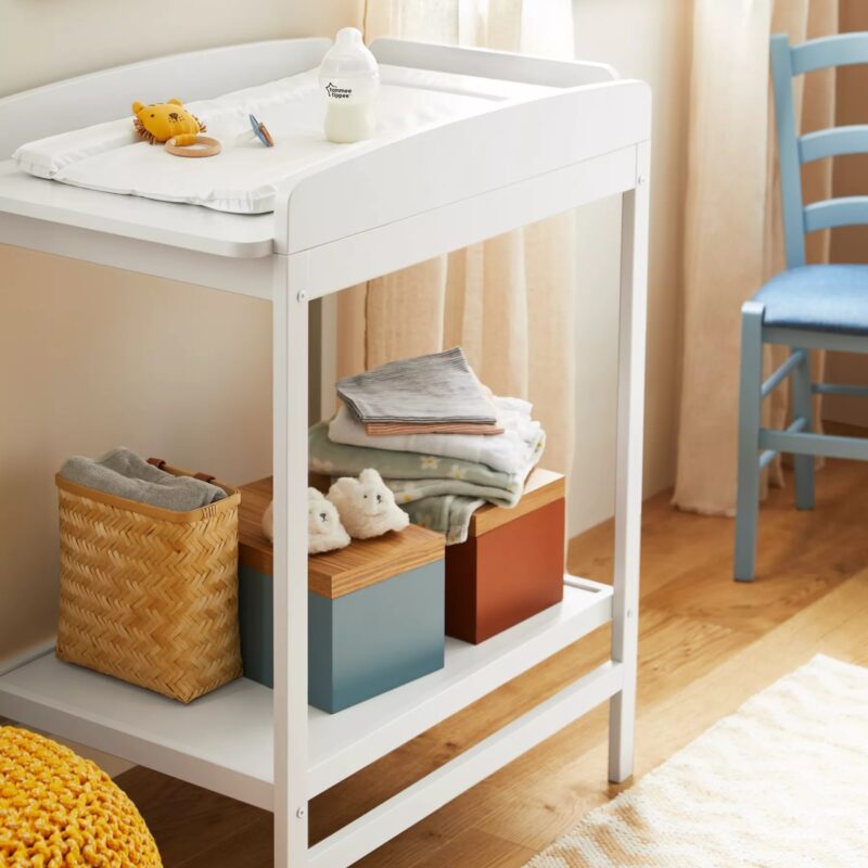 White-painted changer table with storage shelf