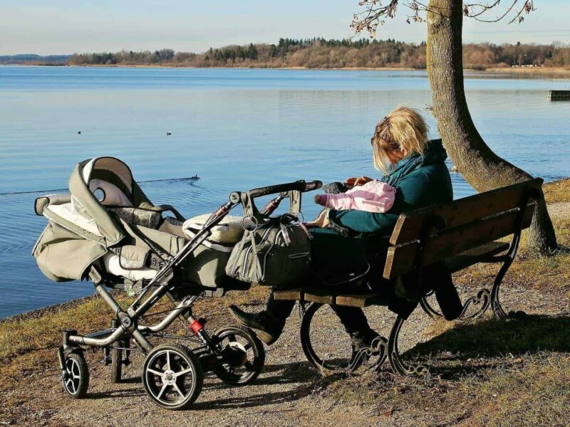 Child minder sat with child by lake