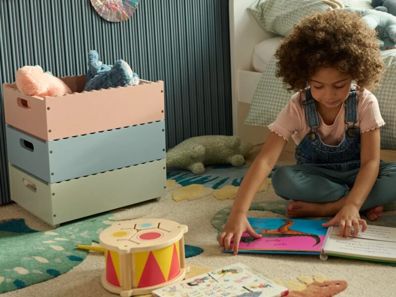 Children's stacking storage boxes painted green, blue and pink