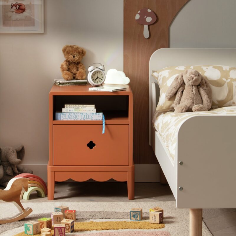 Rust coloured bedside table with scalloped detailing