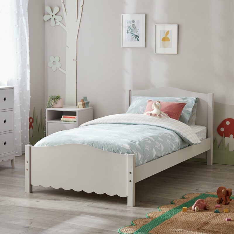 Grey-painted single bed frame with scallop edge detail