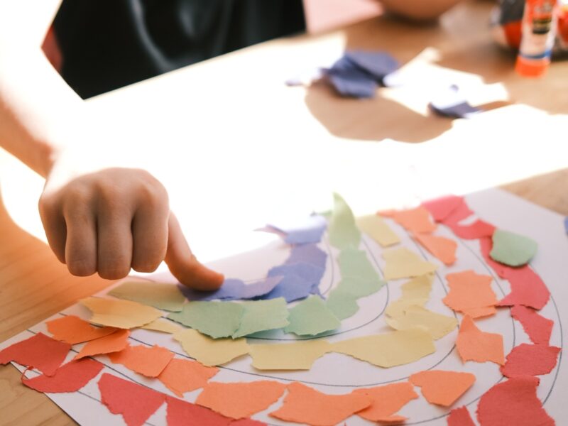 Child crafting with coloured paper